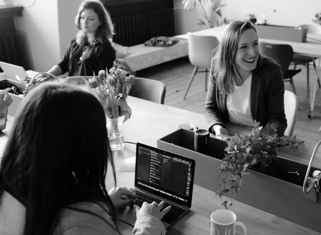 Three women at an office, working and discussing